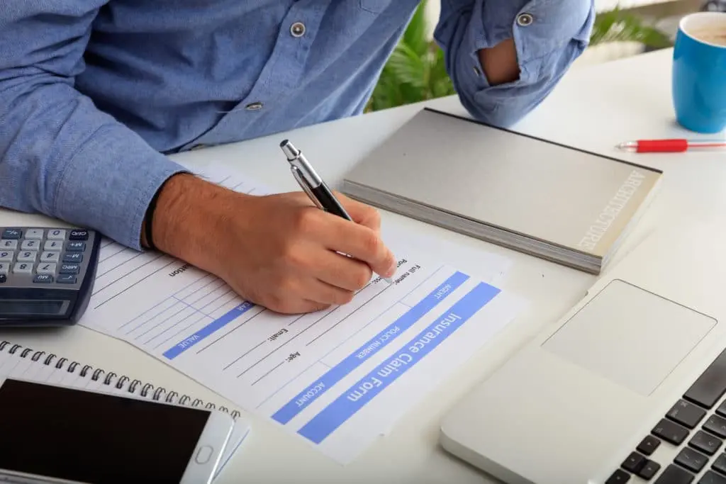 "Man preparing an insurance claim form, illustrating the process of filing and managing insurance claims for medical billing services."